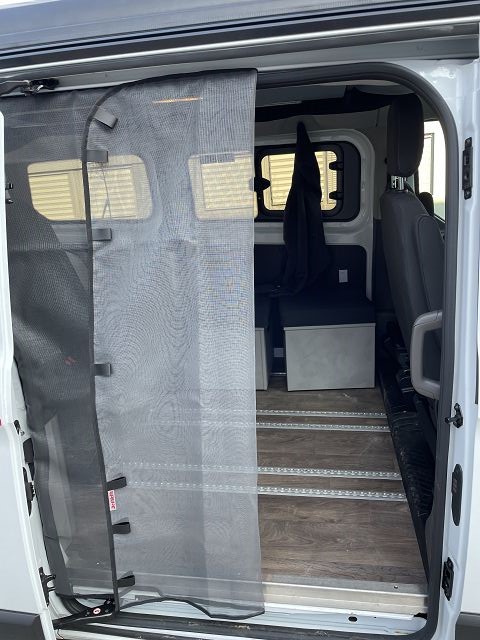 Dethleffs Globevan mit offener Seitentür, braunem innenboden und aufgeklapptem MMoskitonetz