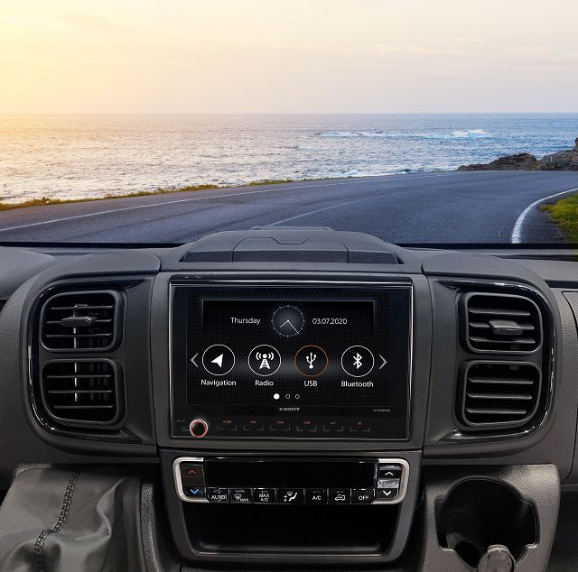 Navigation auf dem Display angezeigt im Auto auf der Straße mit Meer im Hintergrund